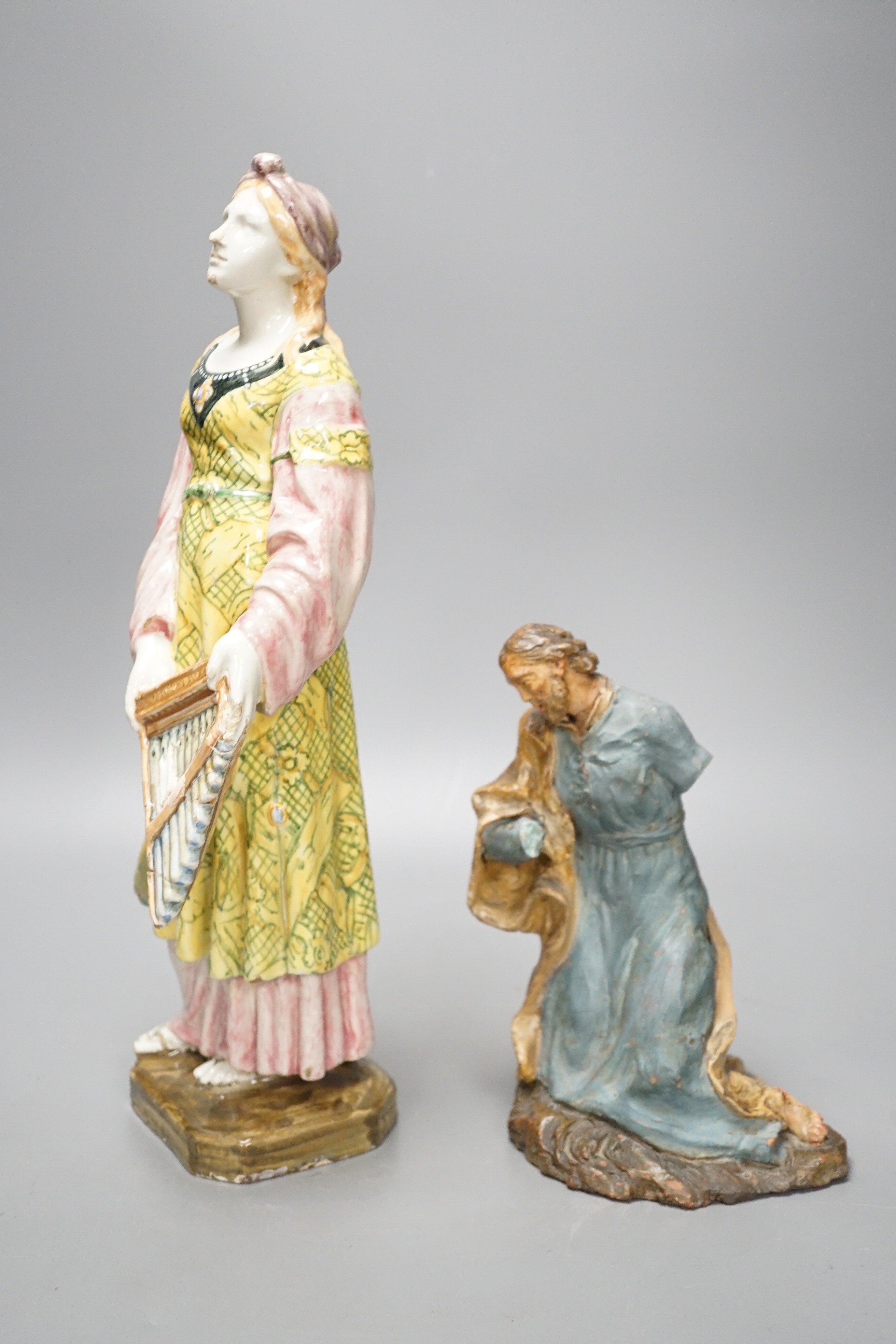 A late 19th century Italian maiolica figure of a Grecian woman or goddess with pipes and Sicilian terracotta figure of a Saint, tallest 38cm